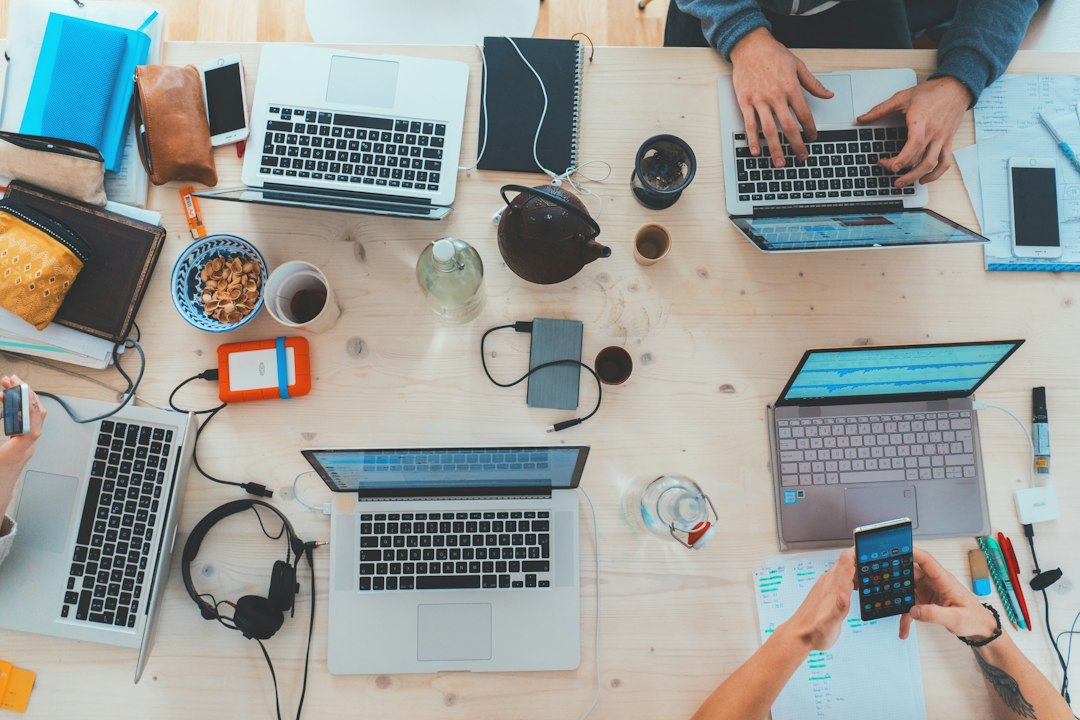Marketing team working on laptops, using AI techniques for Michigan marketers